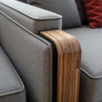 Drewniany podłokietnik dębowy na szarej sofie tapicerowanej