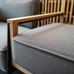 Szara sofa coworkingowa z drewnianym podłokietnikiem dębowym